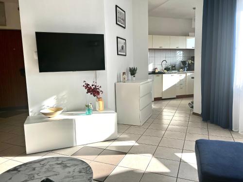a living room with a tv on a wall at Apartament Opal - ul. Grunwaldzka przy plaży in Pobierowo