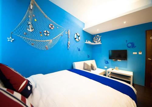 Dormitorio azul con cama con red en la pared en 羅東夜市EazyRoom, en Luodong
