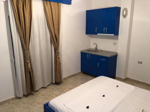 Kleines Zimmer mit blauen Schränken und einem Waschbecken in der Unterkunft Villa Elvis Caca in Ksamil