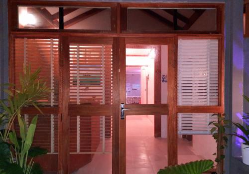 an open glass door with wooden doors and windows at Island Grand Maldives in Hangnaameedhoo