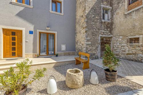 a building with a bench and plants in front of it at Holiday House Lidia i Rina in Pićan