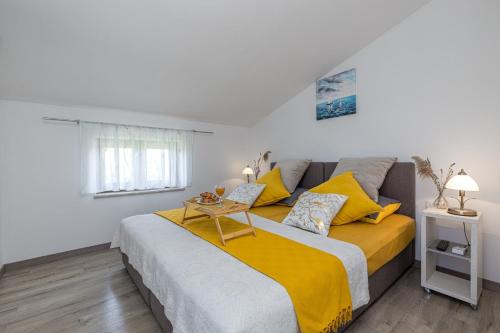 a bedroom with a large bed with yellow pillows at Holiday House Lidia i Rina in Pićan