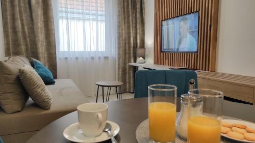 a living room with a table with two glasses of orange juice at Penzion & Vinný bar Régio in Kyjov