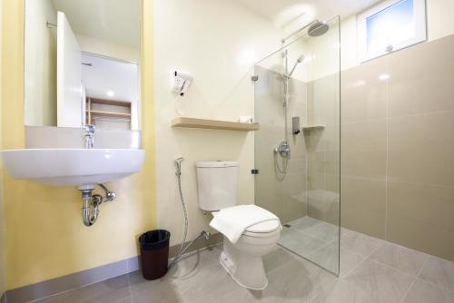 uma casa de banho com um WC, um lavatório e um chuveiro em Hop Inn Hotel Alabang Manila em Manila