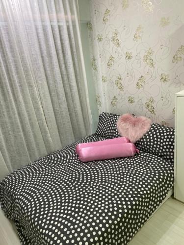 - un lit noir et blanc avec un oreiller rose dans l'établissement Hakone Home Ipoh Majestic, à Ipoh