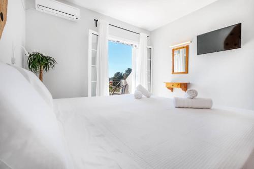 a white room with a large window and a tv at Elena-Stella Apartments Arillas Corfu in Arillas