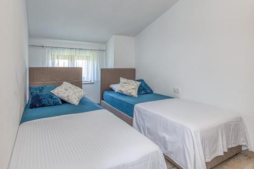 a room with two beds and a table at Holiday House Lidia i Rina in Pićan