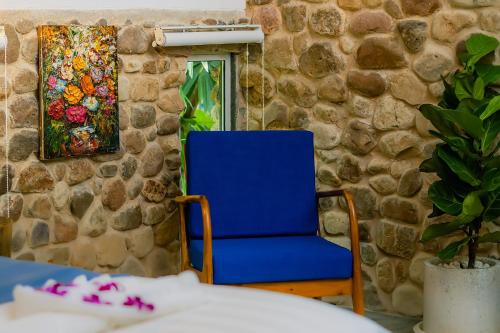 a blue chair in front of a stone wall at Green Valley Veal Pouch in Kampot