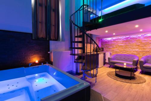 Zimmer mit einer Badewanne und einer Wendeltreppe in der Unterkunft Spa-privatif in Dijon