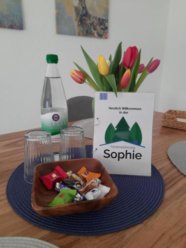 a bowl of food on a table with a vase of flowers at Ferienwohnung Sophie - perfekt mit Kind und Kegel in Eitelborn