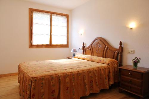 1 dormitorio con 1 cama, vestidor y ventana en Apartamentos Los Tilos, en Benasque