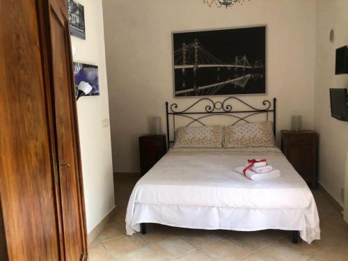 Un dormitorio con una cama con sábanas blancas y zapatos rojos. en Locazione Turistica sita in via Ponte di Ferro 2 a Gualdo Cattaneo en Gualdo Cattaneo