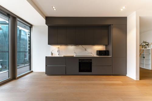 a kitchen with black cabinets and a counter top at Lux City Hamilius - Modern & Spacious Apart w/View in Luxembourg