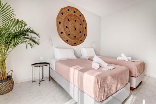 a bedroom with two beds and a mirror on the wall at Elena-Stella Apartments Arillas Corfu in Arillas