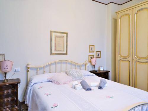 Un dormitorio con una cama blanca con toallas rosas. en Elegant holiday home in the center of Fivizzano in Lunigiana, en Fivizzano