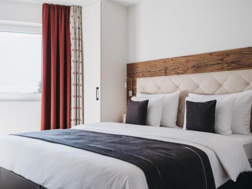 a bedroom with a large bed and a window at Village Park Suites by VAYA inklusive Zell am See Kaprun Sommer Karte in Zell am See