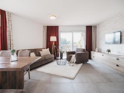 a living room with a couch and a table at Village Park Suites by VAYA inklusive Zell am See Kaprun Sommer Karte in Zell am See