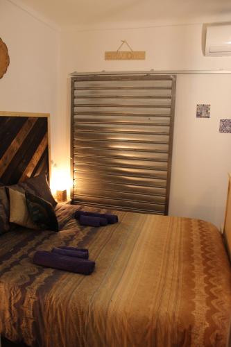 une chambre avec un grand lit avec une grande fenêtre dans l'établissement L'ango-letto industriale del Quadrilatero Romano, à Turin