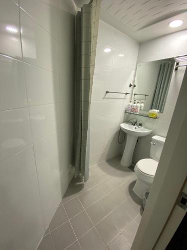 a white bathroom with a toilet and a sink at Seoul Grand Hostel EWHA Univ in Seoul