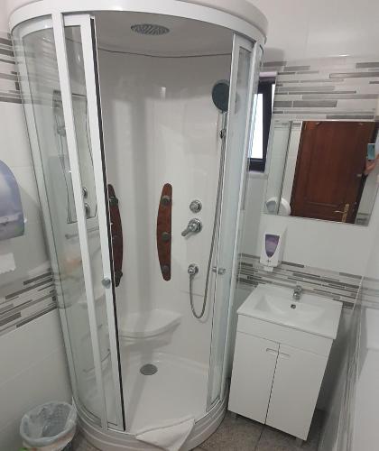 a bathroom with a shower and a toilet and a sink at Sunny House in Lagos