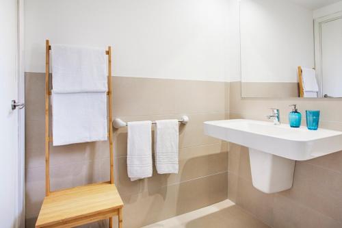 a bathroom with a sink and a mirror and towels at Agulla park in Cala Ratjada