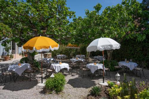 two tables and chairs with umbrellas in a garden at Lou Cagnard in Saint-Tropez
