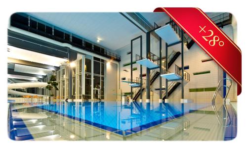 a building with a swimming pool in front of it at Hotell Fritidsparken in Skien