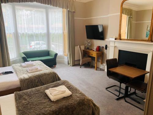 a hotel room with two beds and a fireplace at Hedley House Hotel & Apartments in York