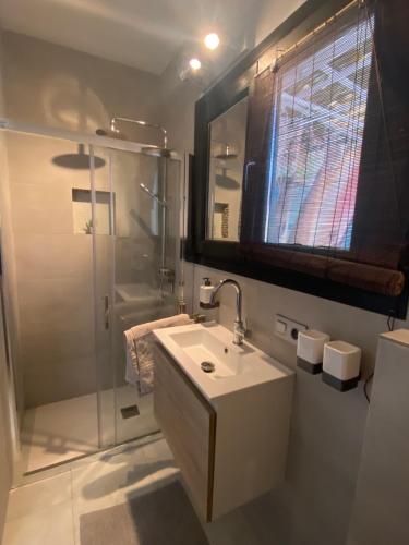 uma casa de banho branca com um lavatório e um chuveiro em Casa Previsio em Cala Pi