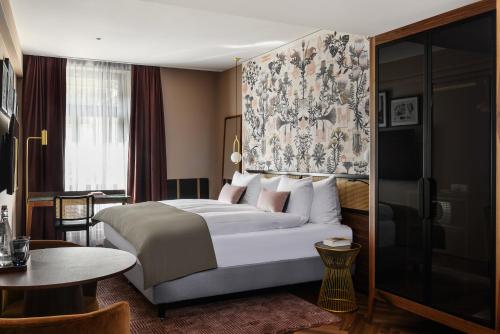チューリッヒにあるBoutique Hotel Seidenhofの大きなベッドとテーブルが備わるホテルルームです。