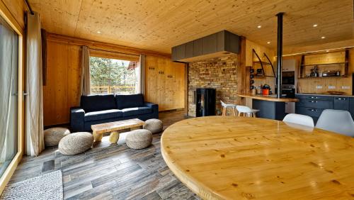 Il comprend un salon avec une table en bois et une cuisine. dans l'établissement Chalet Gîte Magali de 2 à 12 pers, à Le Noyer
