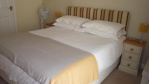 斯坦福德的住宿－小附樓住宿加早餐旅館，一张带白色床单和枕头的床以及床头柜