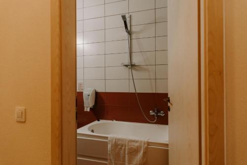 La salle de bains est pourvue d'une baignoire et d'un téléphone mural. dans l'établissement Casa Maria Magdalena, à Lipova