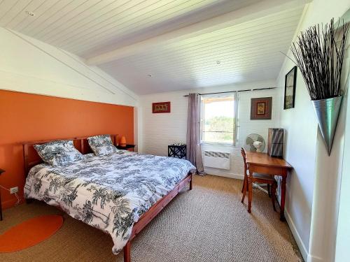 a bedroom with a bed and a desk and a window at Ferme de Mouline in Sainte-Foy-la-Longue