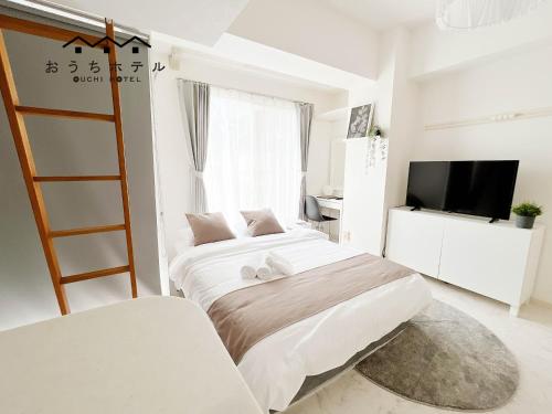 a white bedroom with two beds and a television at OUCHI HOTEL Fujimi in Hiroshima