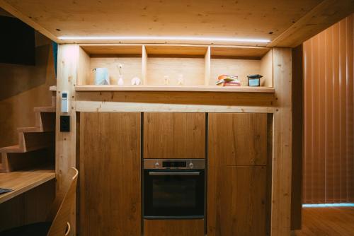 a small kitchen with wooden walls and a stove at Domaine Bohème I art de vivre in Guebwiller