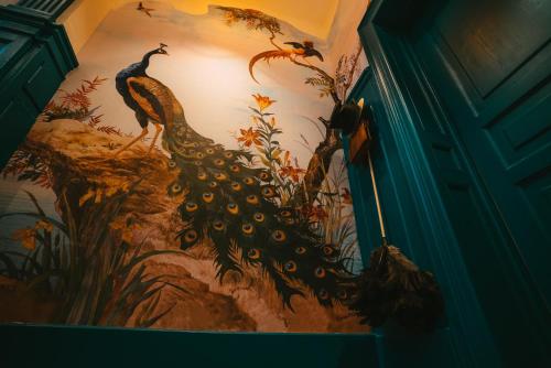 a painting of a peacock on a wall at Domaine Bohème I art de vivre in Guebwiller