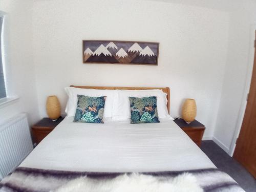 a bedroom with a bed with two pillows at Sawmill Cottage in Grantown on Spey