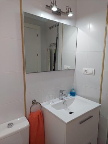 La salle de bains est pourvue d'un lavabo, d'un miroir et de toilettes. dans l'établissement Ático by Alhaurín Loft City Center, à Alhaurín de la Torre