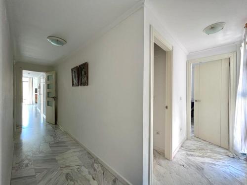 an empty hallway with white walls and a marble floor at Bear Holiday - Apartment Lynn with Seaview in Moraira near the Beach in Moraira