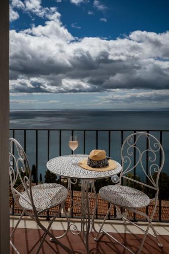 a table and chairs on a balcony with the ocean at Hotel Elios Tao in Taormina