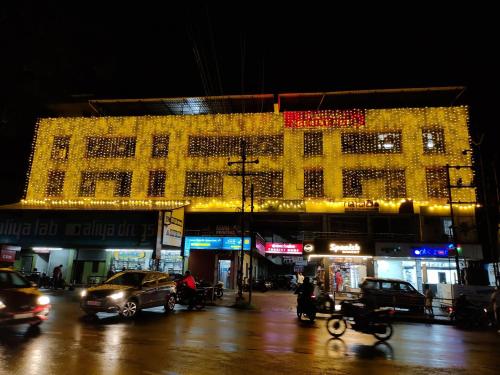 een groot gebouw met kerstverlichting op de avond bij Marhaba Tourist Home in Kozhikode
