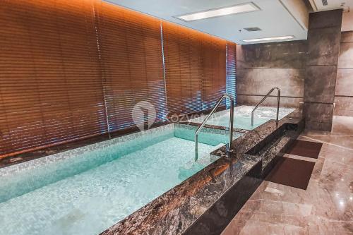 a large swimming pool in a room with a large window at Cedar by Kozystay - Setiabudi in Jakarta