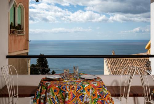 a table and chairs on a balcony with a view of the ocean at Hotel Elios Tao in Taormina