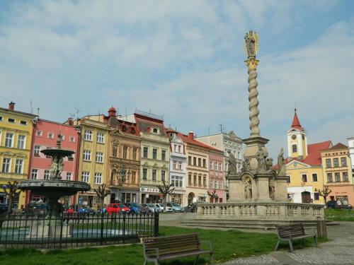 a statue in the middle of a city with buildings at Apartmán U Kláštera in Broumov
