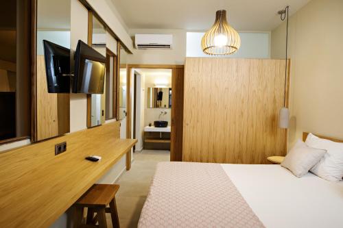 a bedroom with a bed and a desk with a television at Fedra Plakias Apartments in Plakias