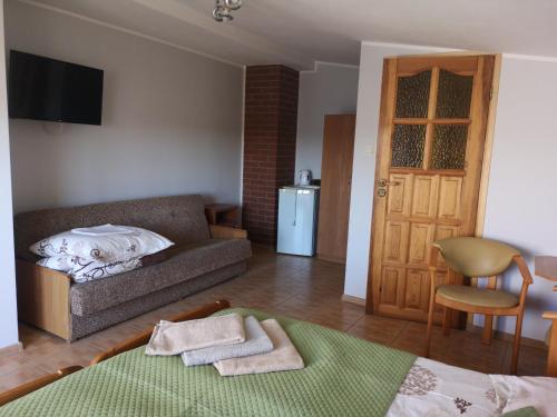 ein Wohnzimmer mit einem Sofa und einem Tisch in der Unterkunft Dom wczasowy Płomyk in Władysławowo