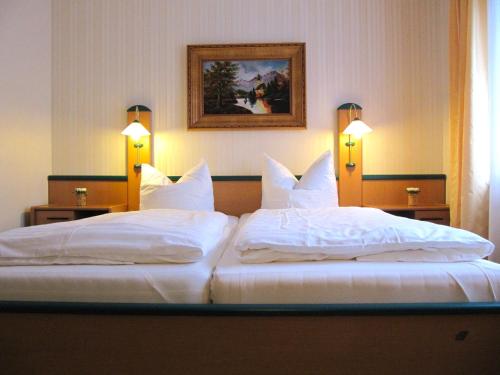 two beds in a hotel room with white pillows at Hotel Garni Zur Traube in Höhr-Grenzhausen