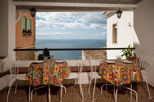 a balcony with two tables and a view of the ocean at Hotel Elios Tao in Taormina
