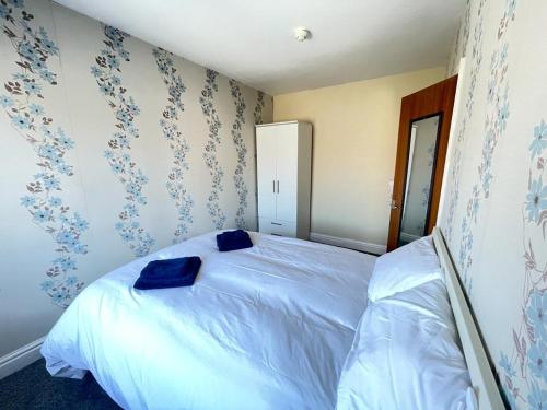 a bedroom with a bed with two blue pillows on it at 1 Bedroom Holiday Apartment Skegness - Flat 14 in Skegness